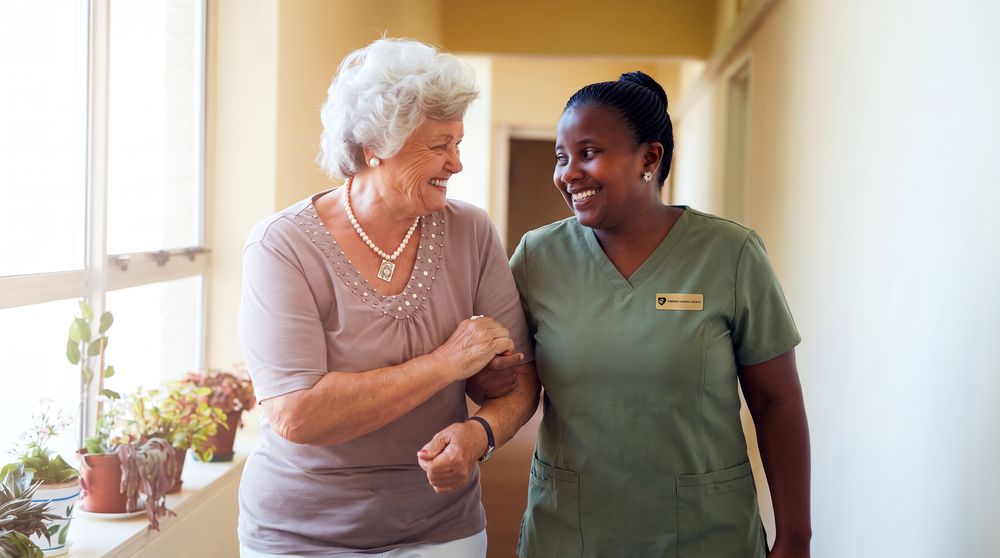 A caregiver steadying a client on her feet